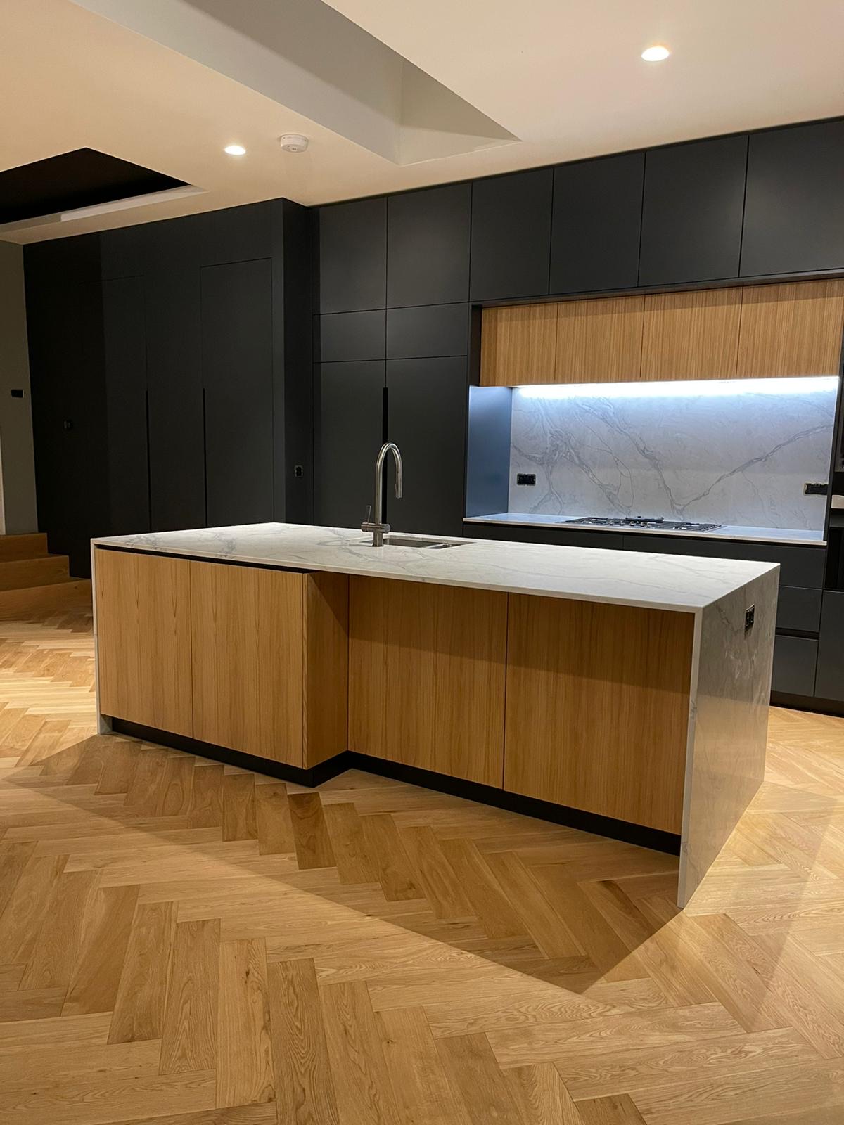 charcoal black kitchen with oak floor and marble worktop