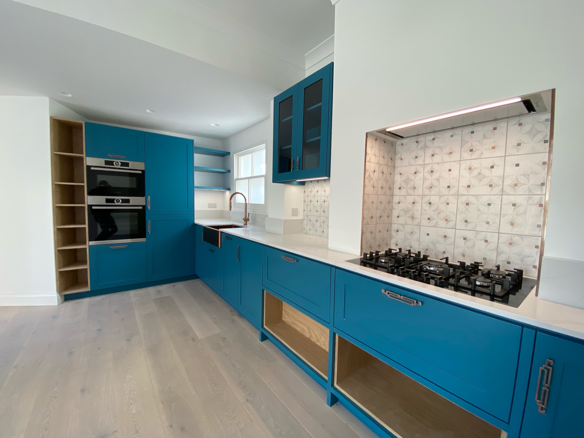kitchen with teal cabinets and copper sink